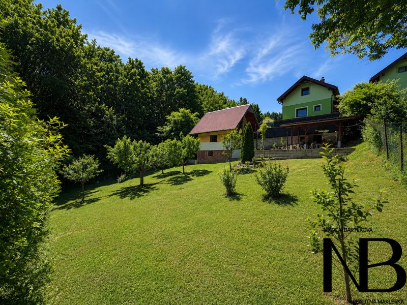 Hütte auf Klučina in Považská Bystrica mit gepflegtem Garten, Bäumen und grünem Gras.