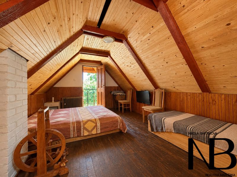 Dachzimmer in der Hütte mit Holzeinrichtung und Bett.
