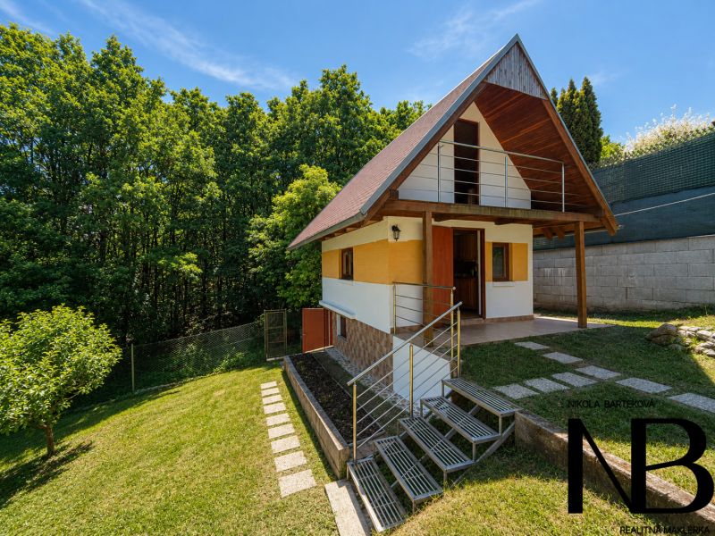 Eine Hütte mit Holzelementen in Považská Bystrica auf Klučina, umgeben von Grün und Bäumen.