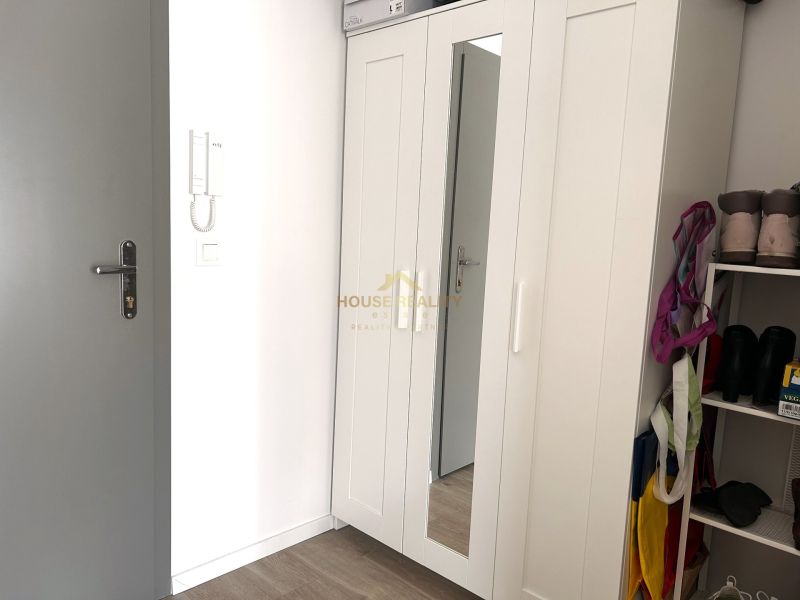 Einbauschrank mit weißen Türen und Spiegel in einer Einzimmerwohnung.
