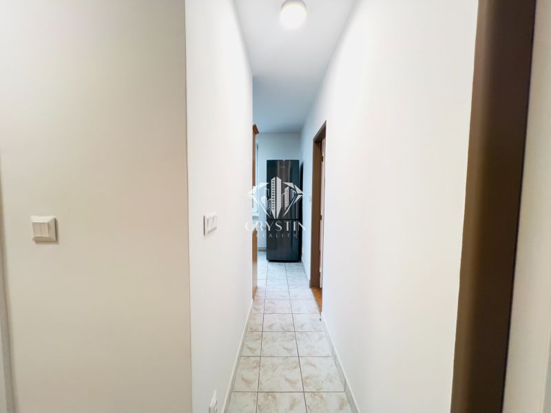 Ein Flur mit Fliesen, der zu den Zimmern in einer 2-Zimmer-Wohnung führt.