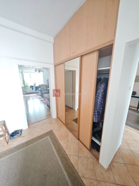Einbauschrank und Fliesen im Flur einer 2-Zimmer-Wohnung mit Holzboden-Dekor.