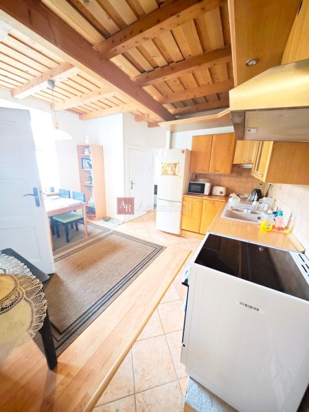 Küche in einer 2-Zimmer-Wohnung mit Holzboden und Holzdecke.