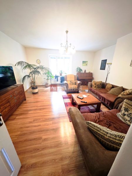 Wohnzimmer in einer 2-Zimmer-Wohnung mit Holzboden und einem bequemen Sofa.