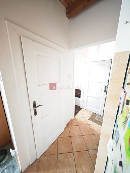 Eingangsbereich in einer 2-Zimmer-Wohnung mit Keramikfliesen und weißen Türen.