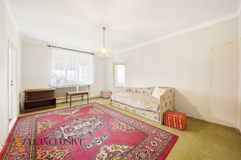 Wohnzimmer in einem Einfamilienhaus mit Teppich und Sofa, schlichtes Interieur.
