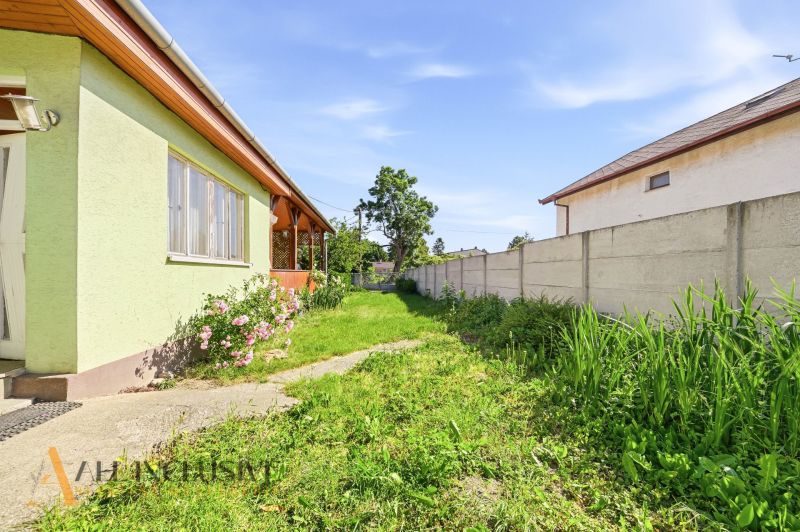 Garten bei einem Einfamilienhaus in Hviezdoslavov mit Rasen und Blumen, eingezäunt.