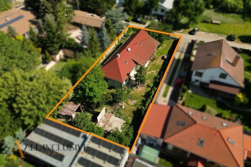 Ein Einfamilienhaus in Hviezdoslavov mit rotem Dach, umgeben von Grünflächen und weiteren Gebäuden.
