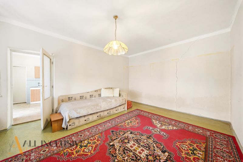Ein Zimmer in einem Einfamilienhaus mit einem Bett, Licht und einem orientalischen Teppich.