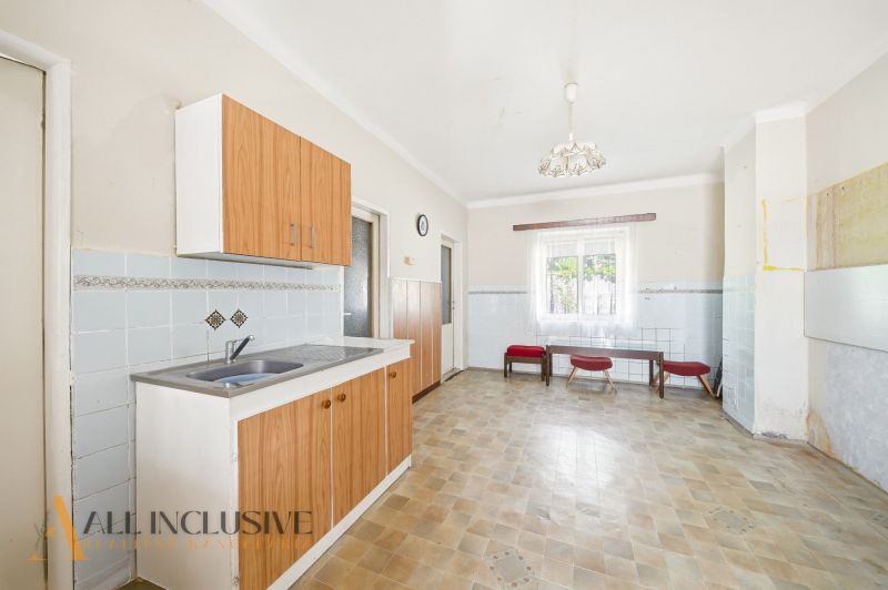 Küche mit Holzschränken und Fliesen, in einem Einfamilienhaus.