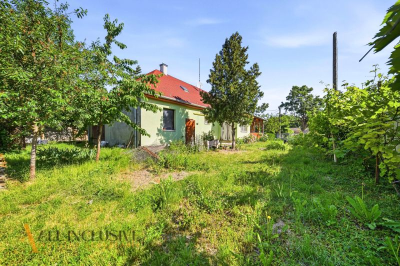 Ein Garten und ein Einfamilienhaus in Hviezdoslavov, umgeben von Bäumen und Grün.