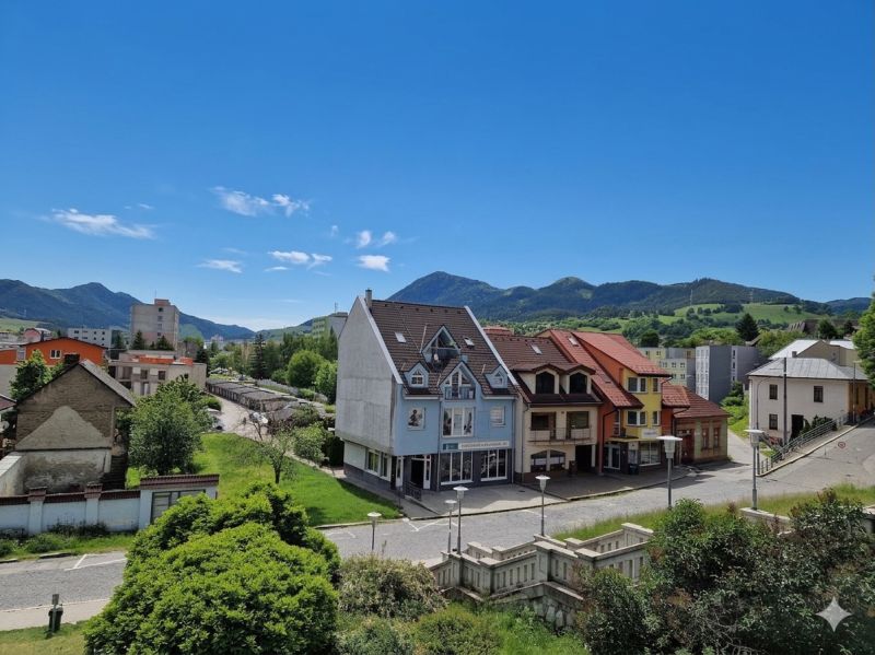 Ein Blick auf die Gebäude und Straßen in Ružomberok, mit grünen Hügeln im Hintergrund.
