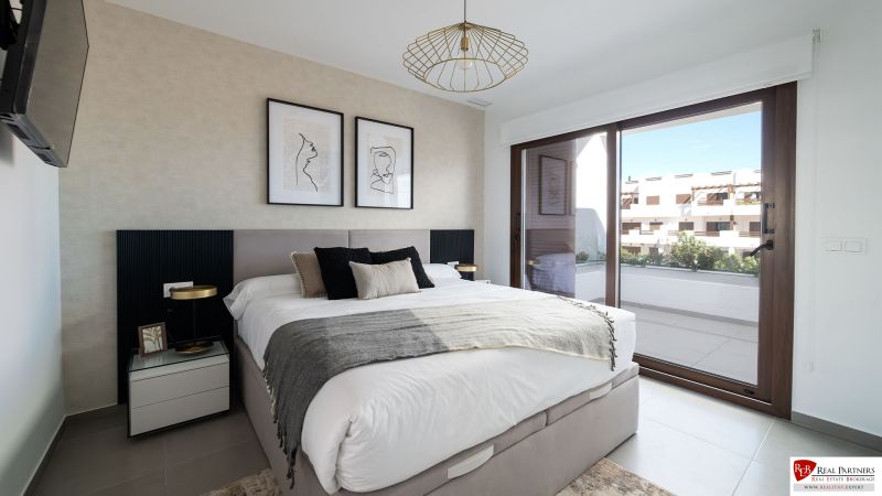 Schlafzimmer in einer 2-Zimmer-Wohnung mit großem Fenster, Kunst an der Wand und komfortablem Bett.