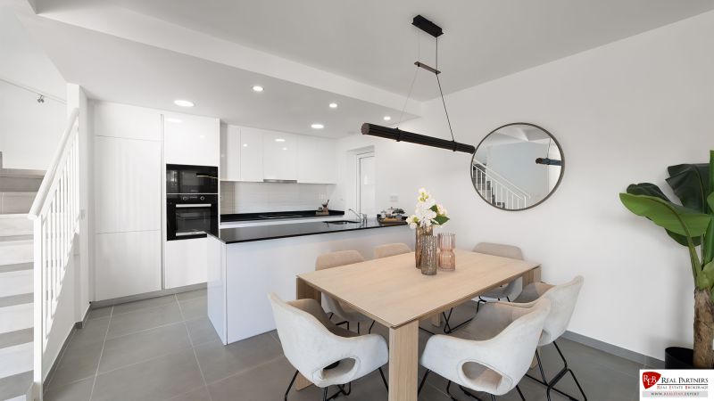 Esszimmer in einer 2-Zimmer-Wohnung mit geräumigem Tisch und Küche.
