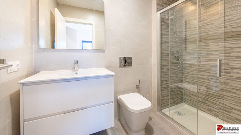 Badezimmer in einer Ferienwohnung mit großer Dusche und elegantem Waschbecken.
