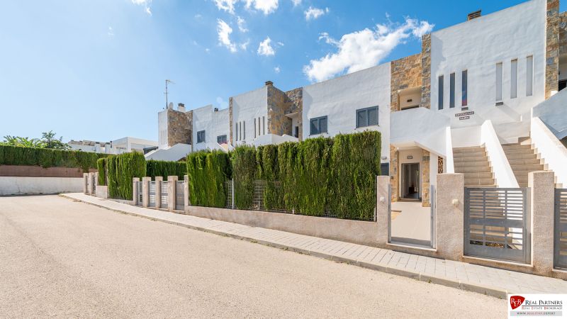 Ferienwohnung in Cala Murada auf Mallorca mit Reihenhausbebauung, umgeben von Grünflächen.