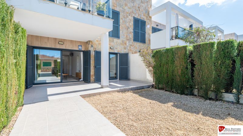 Ferienwohnung in Cala Murada Mallorca mit Terrasse, Steinwänden und Garten.