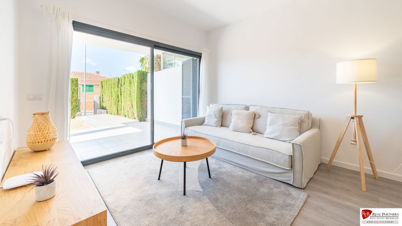 Ferienwohnung mit bequemem Sofa, Tisch und großem Fenster.