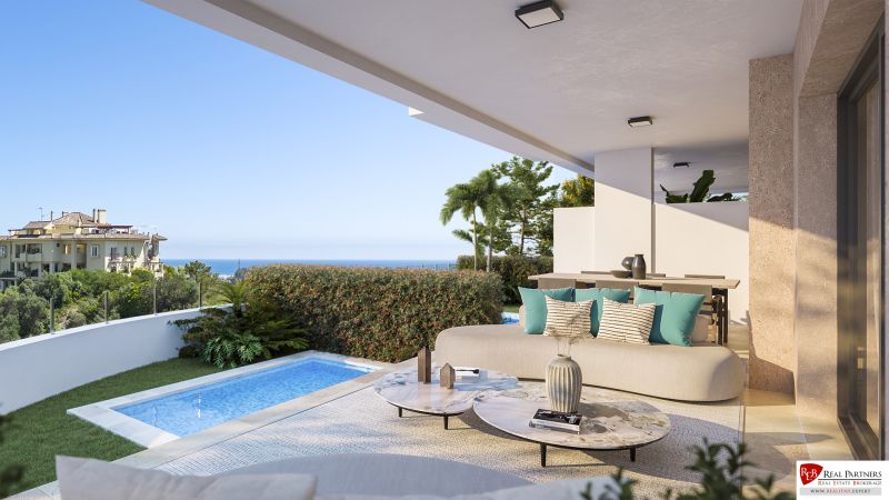 Terrasse einer Ferienwohnung in Estepona mit Pool, Meerblick und komfortabler Sitzgelegenheit.