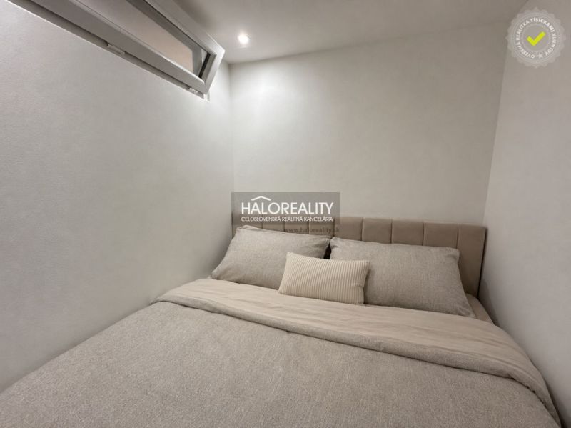 Gästezimmer in einer Einzimmerwohnung mit minimalistischem Design und komfortablem Bett.