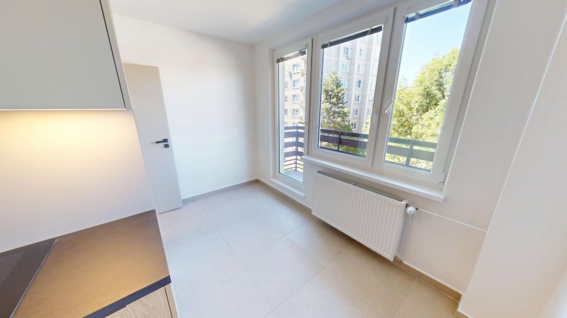 Helle Küche mit großen Fenstern und Heizkörper in einer 2-Zimmer-Wohnung.