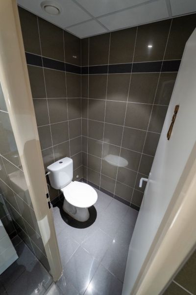 Badezimmer mit grauen Fliesen und Toilette in außergewöhnlichen Immobilien.