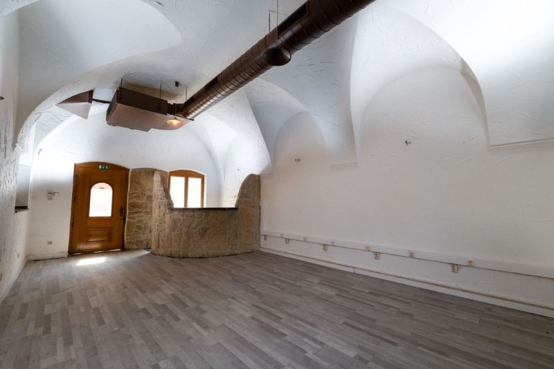 Ein Innenraum mit einem gewölbten Decken und einem Boden mit Holzdekor. Besondere Immobilien.