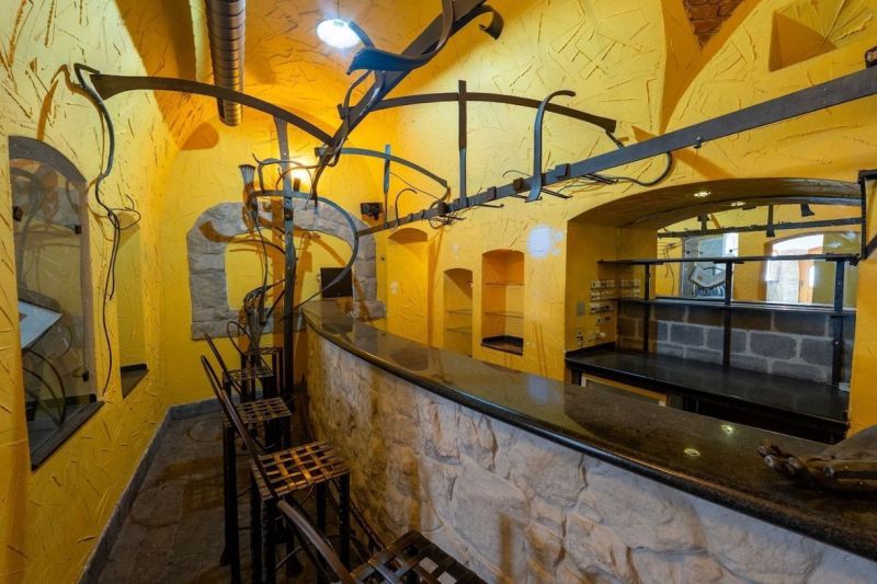 Ein Innenraum mit gelben Wänden, einer Steinbar und Metallkonstruktionen, Ungewöhnliche Immobilien.