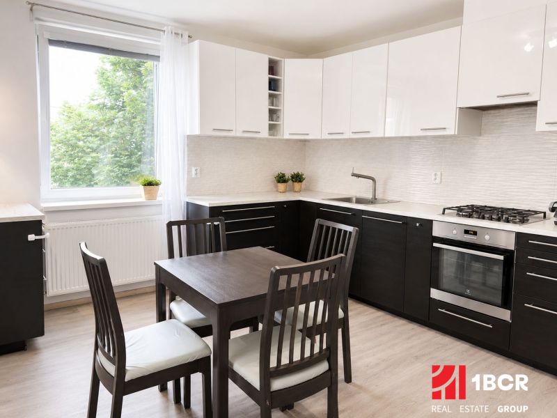 Küche in einer 3-Zimmer-Wohnung mit Esstisch und Boden in Holzoptik.