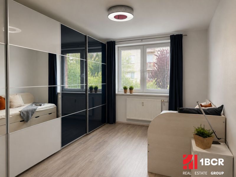Ein Zimmer in einer 3-Zimmer-Wohnung mit einem Boden in Holzoptik und einem großen Kleiderschrank.
