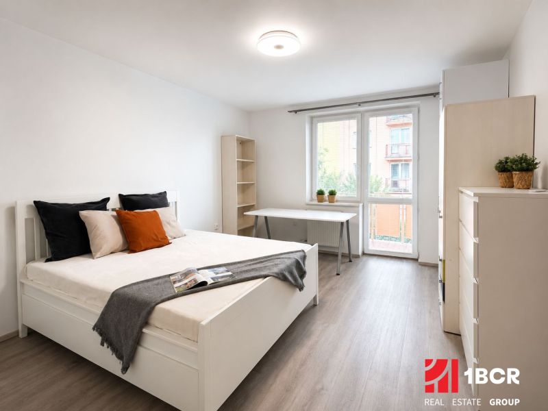 Schlafzimmer in einer 3-Zimmer-Wohnung mit Bett, Tisch und Holzboden.