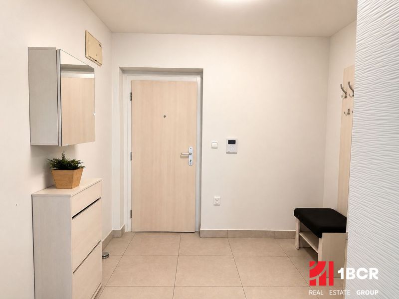 Eingangsbereich in einer 3-Zimmer-Wohnung; helle Wände, Fliesenboden, Spiegel, Stauraum und Sitzbank.