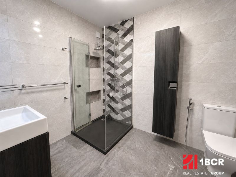 Badezimmer mit moderner Duschkabine und Fliesen in einer 3-Zimmer-Wohnung.