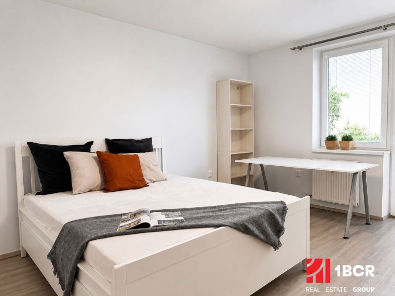 Helles Schlafzimmer in einer 3-Zimmer-Wohnung mit Holzboden und Schreibtisch.