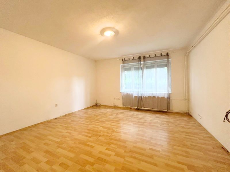 Innenraum eines Einfamilienhauses mit großem Fenster und Boden in Holzoptik.