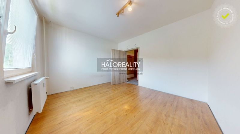 Ein Zimmer in einer 3-Zimmer-Wohnung mit einem Holzboden und weißen Wänden.