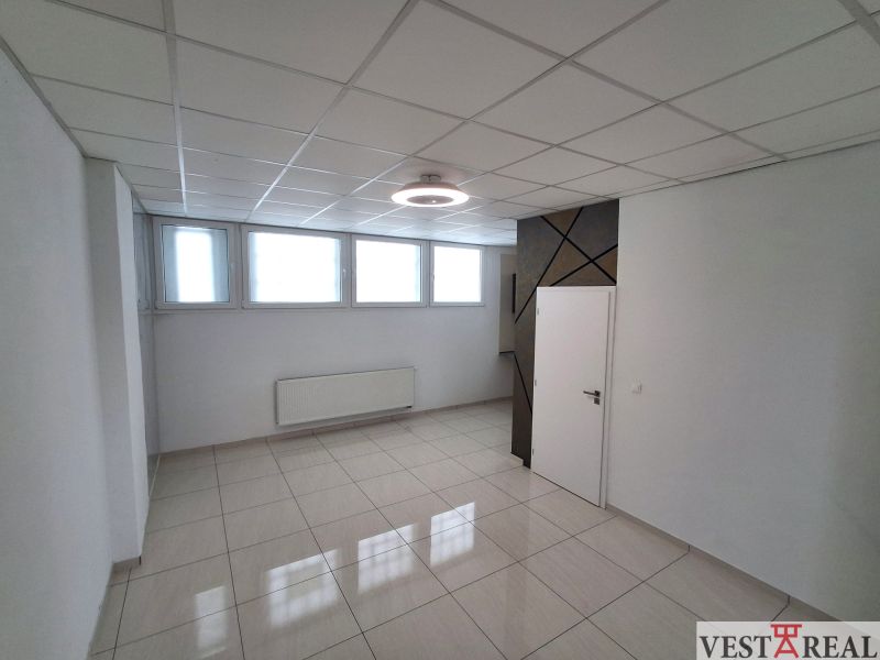 Büros mit hellem Fliesenboden, weißen Wänden und Fenstern, schlichtem Deckendesign.