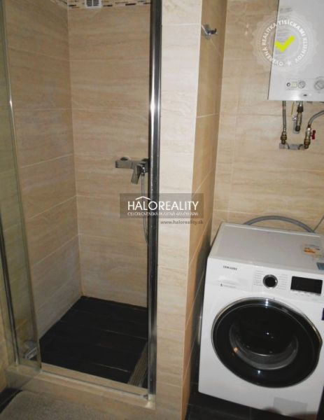 Badezimmer mit Waschmaschine und Duschkabine in einer 3-Zimmer-Wohnung.
