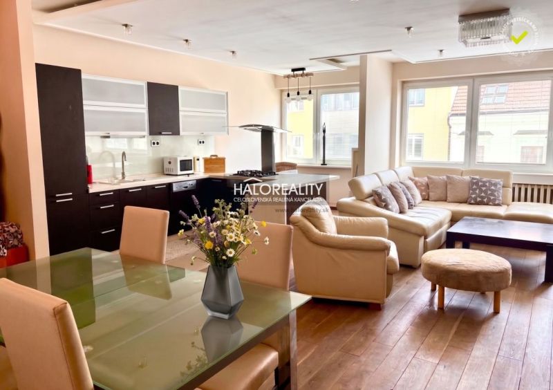 Küche mit weißen Möbeln, Ledersofa, Boden mit Holzdekor in einer 3-Zimmer-Wohnung.