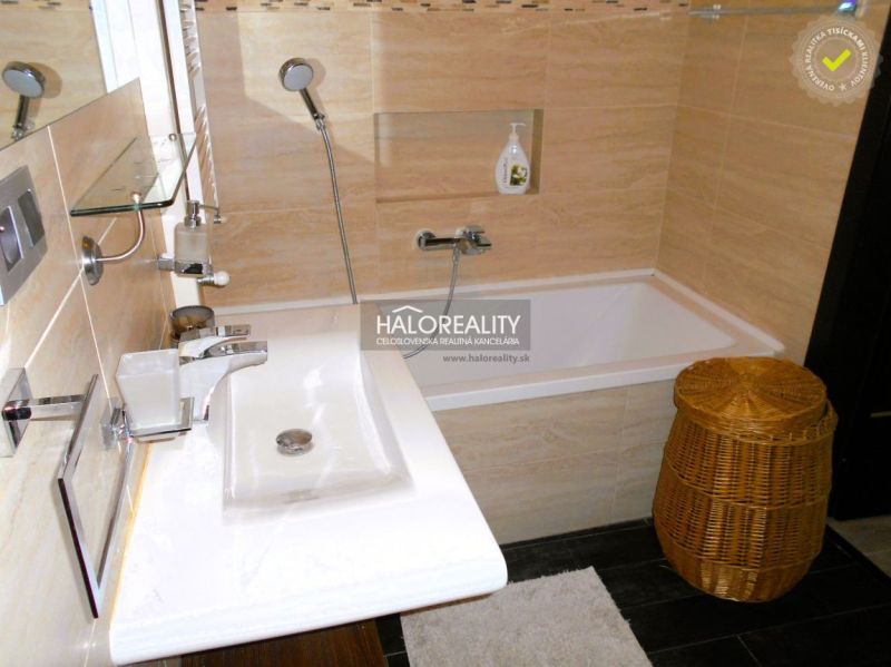 Badezimmer mit Waschbecken, Badewanne und Korb in einer 3-Zimmer-Wohnung.