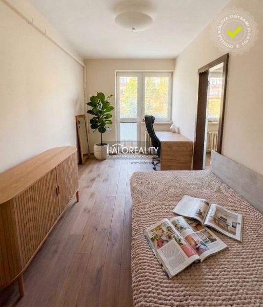Helles Zimmer mit Holzboden und Möbeln in einer 3-Zimmer-Wohnung.