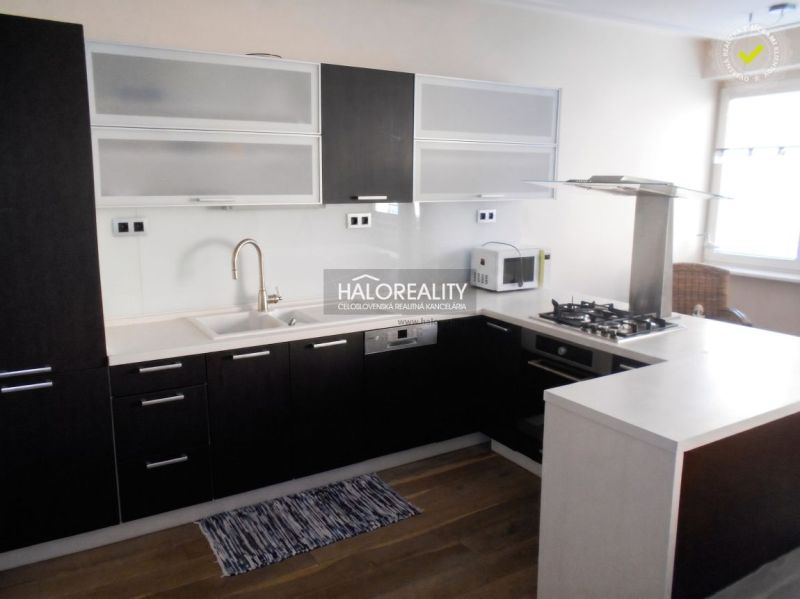Küche in einer 3-Zimmer-Wohnung mit Holzboden und moderner Küchenzeile.
