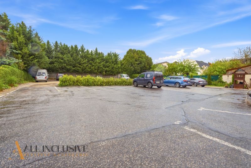 Parkplatz in Nitra, umgeben von Grünflächen und Autos in Gastrobereichen.