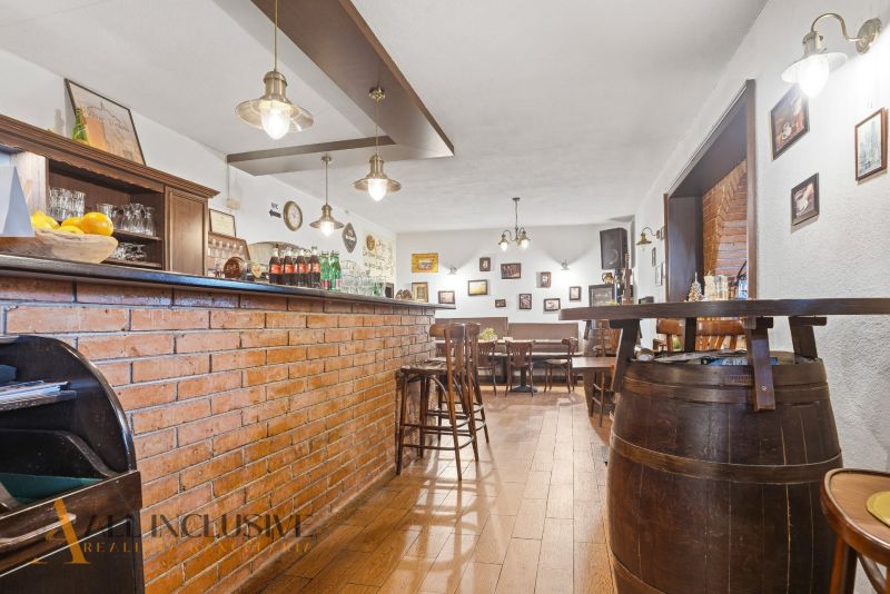 Backsteinbar und -hocker in Gastronomieräumen mit Holzboden.