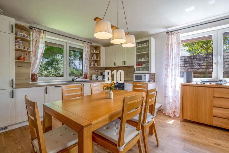 Küche in einem Einfamilienhaus mit Holztisch und Dekor, in hellen Farben.