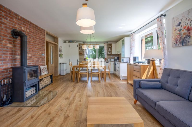 Wohnzimmer mit Holzboden, Kamin und Esstisch in einem Einfamilienhaus.