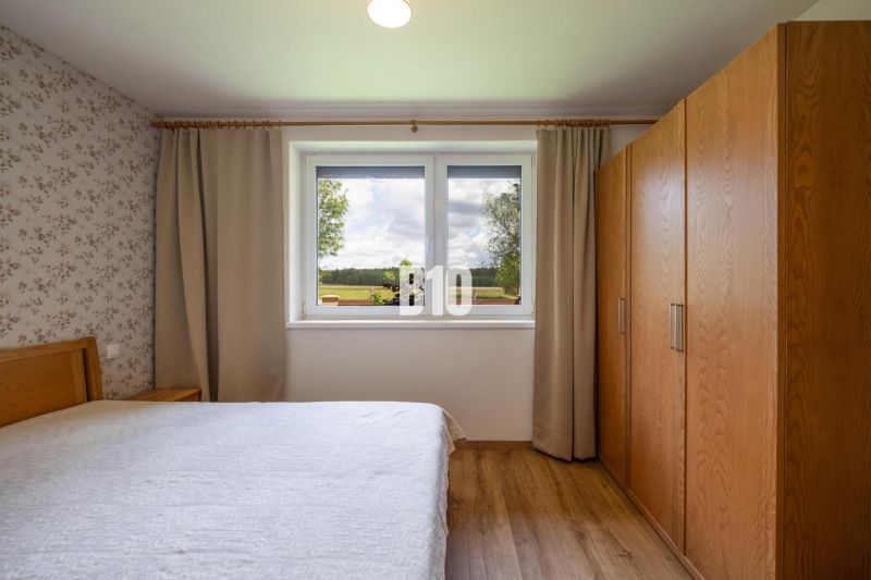 Schlafzimmer mit Holzboden und Blick aus dem Fenster in einem Einfamilienhaus.