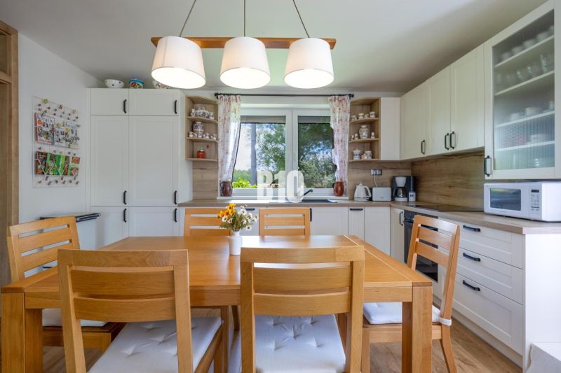 Eine Küche in einem Einfamilienhaus mit Holzmöbeln und dekorativen Accessoires.