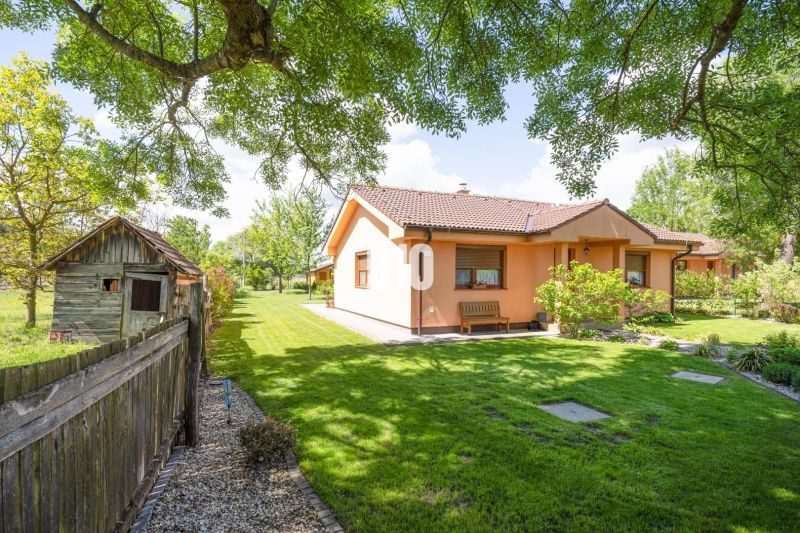 Ein Einfamilienhaus in Bílkove Humence, umgeben von einem Garten mit Bäumen und Rasen.
