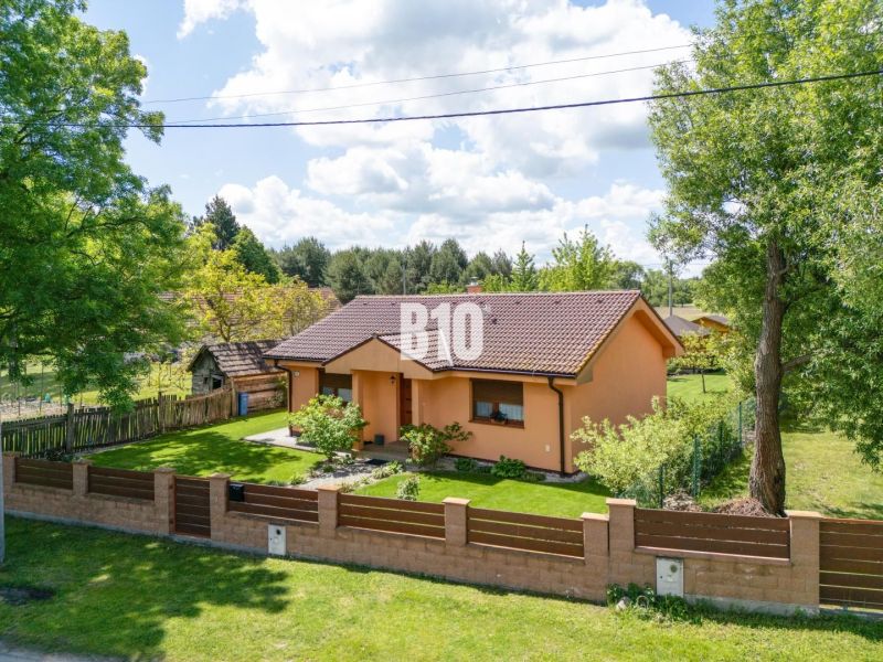 Ein Einfamilienhaus in Bílkove Humence mit einem gepflegten Garten und einer Terrakotta-Fassade.